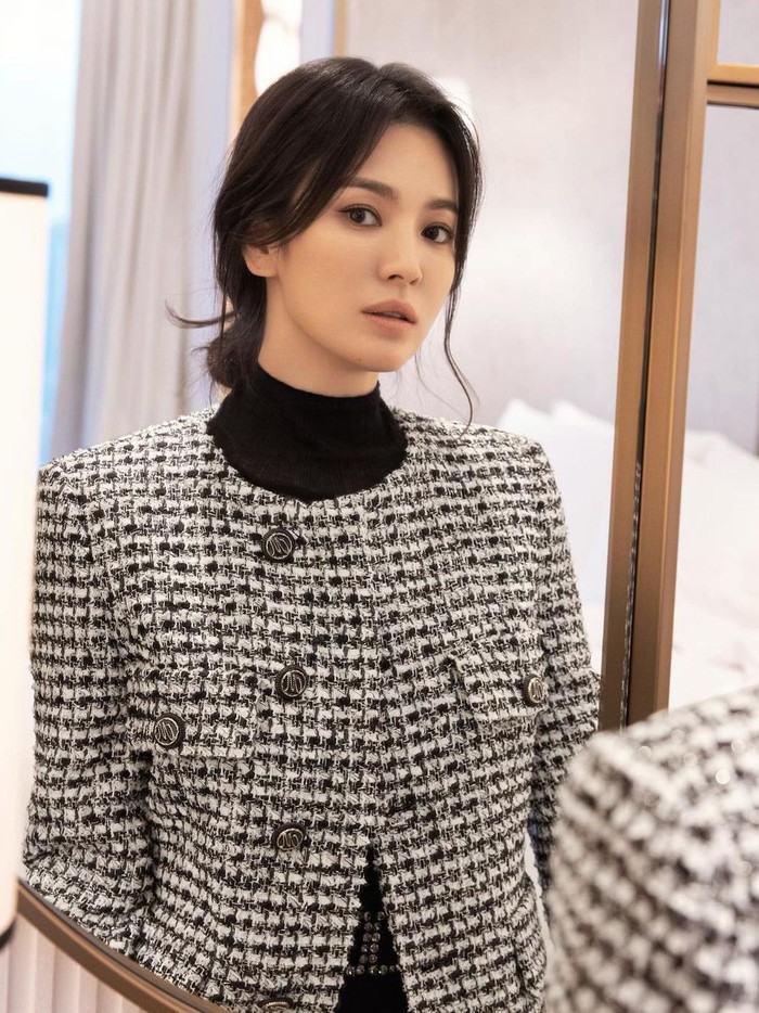 Untuk gaya selanjutnya, Song Hye Kyo tampil dengan gaya preppy look mengenakan inner berwarna hitam yang dipadukan dengan jaket model tweed. Warna hitam, putih, serta abu-abu membuat gaya minimalisnya makin menonjol. Tak lupa, Song Hye Kyo mengenakan riasan minimalis untuk melengkapi penampilannya./Foto: Yeongjun Kim