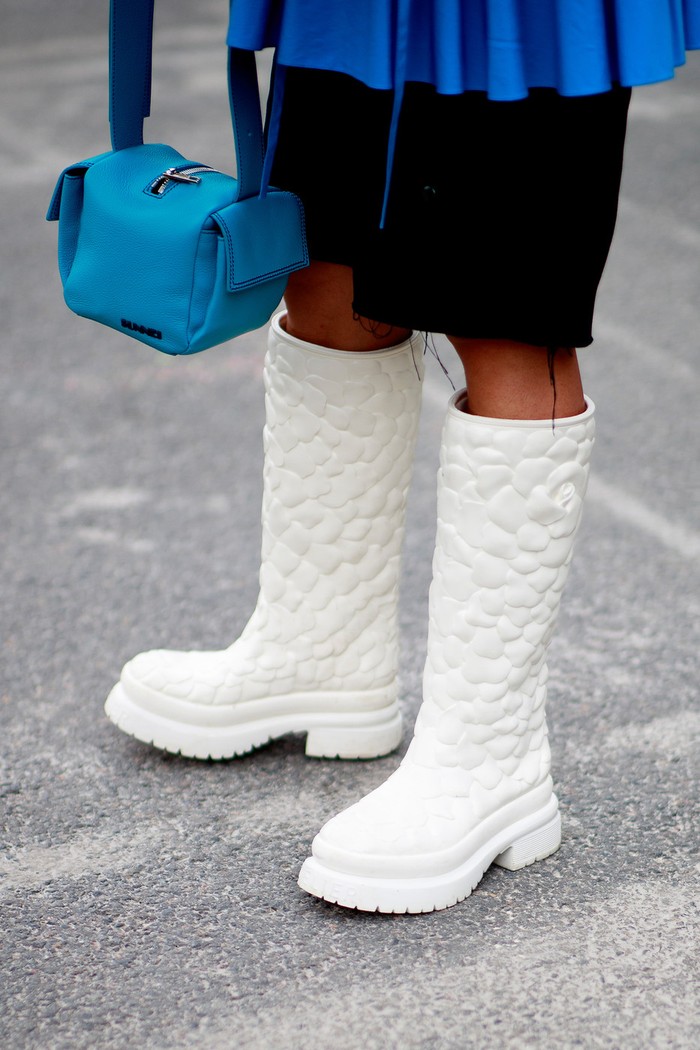 Rain boots dalam warna putih berdetail embossed corak bunga memberi statement tersendiri pada busana minimalis. Foto: livingly.com/IMAXtree