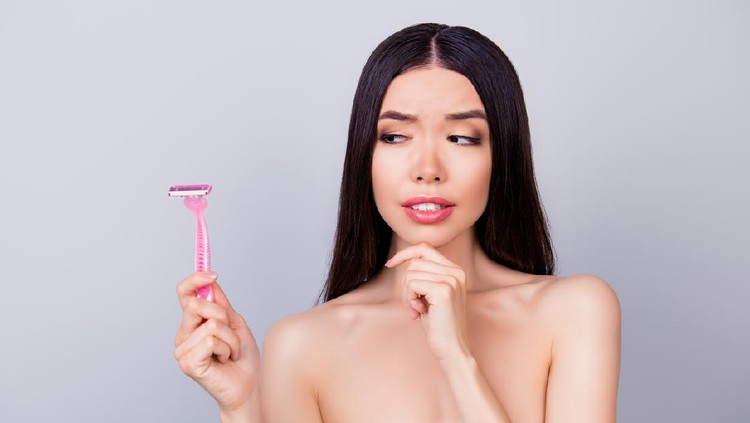 ilustrasi razor burn area vagina Young unsure nervous asian girl with pink shaver is standing isolated on a grey background, wrapped in a white towel, doubting if she should use it