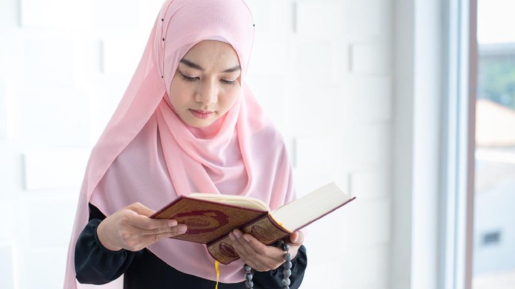 Young beautiful Muslim Woman Praying In Mosque.