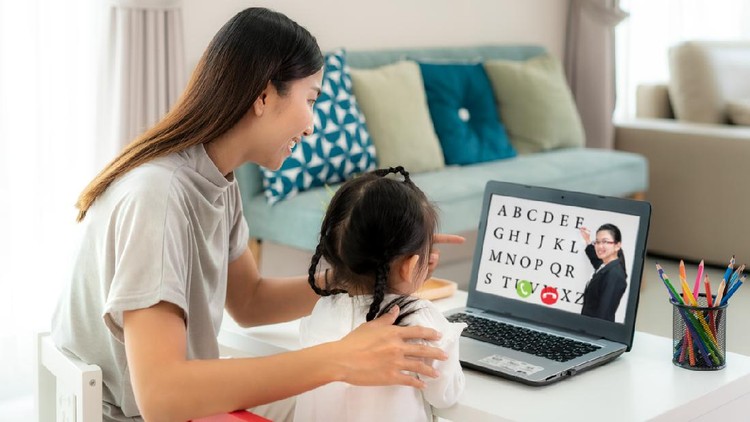 Asian kindergarten school girl with mother video conference e-learning with teacher on laptop in living room at home. Homeschooling and distance learning ,online ,education and internet.