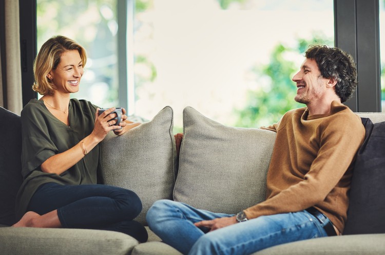 ilustrasi pasangan Shot of a mature couple chatting and having coffee while relaxing on the sofa at home