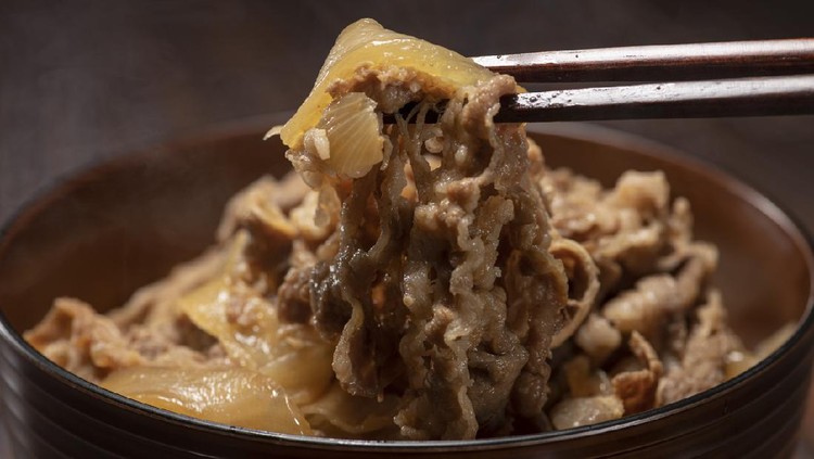 rice bowl beef Bowl of rice topped with cooked beef and onions.
