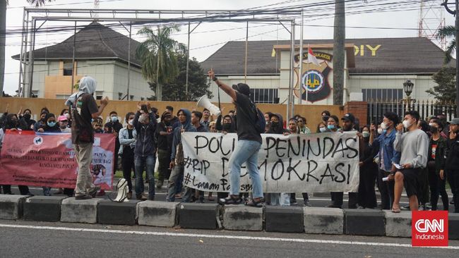 Massa aksi menuntut polisi yang membanting mahasiswa ala smackdown diadili agar aparat tidak mengulang kekerasan yang sama.
