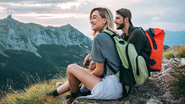 young couple of hikers enjoying the beautiful nature from high above