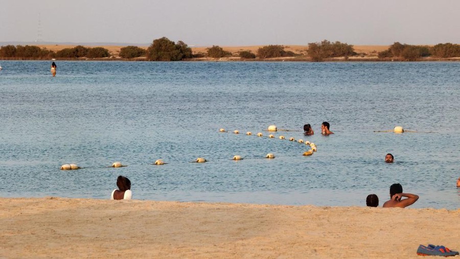 Beachgoers play at floating blow-up water park, at Pure Beach in King Abdullah Economic City -- about 125 kilometres south of Jeddah's city centre, on the Red Sea, on September 17, 2021. - While tourists have long been able to mingle freely at such parties in and around Jeddah, known as the kingdom's most open-minded city, Saudis were confined to single-sex beaches. But now, four years into a reform drive aimed at improving the country's image and creating new opportunities for its oil-reliant economy, they are enjoying more freedoms. (Photo by Fayez NURELDINE / AFP)