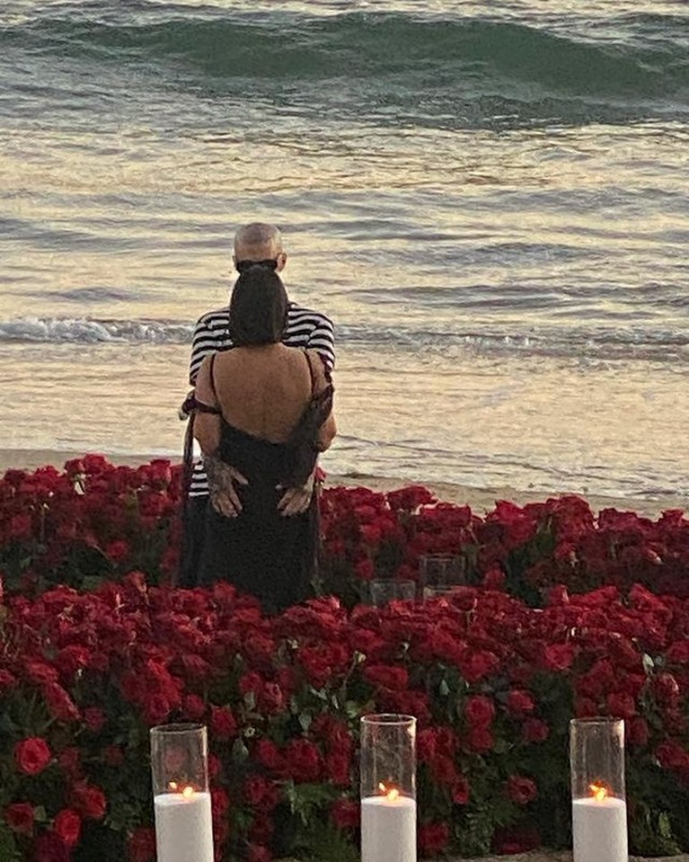 Travis Barker melamar Kourtney Kardashian dengan cara romantis di tepi pantai penuh bunga mawar. Yuk intip!