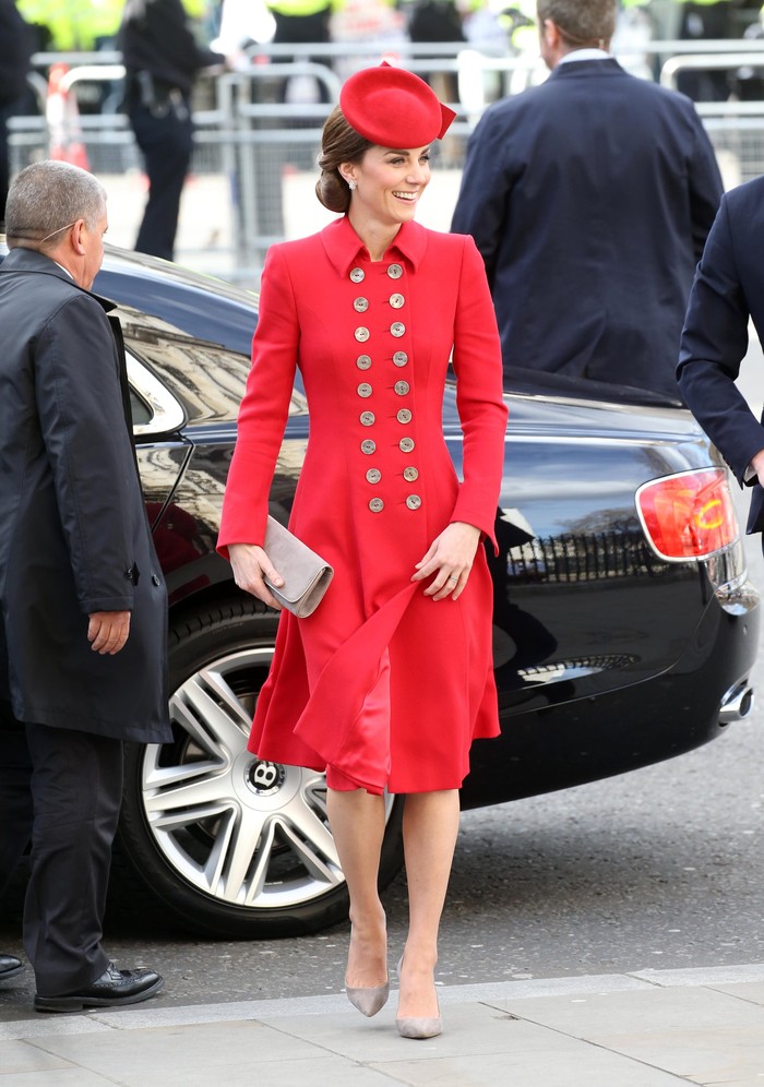 Kate Middleton hadiri Commonwealth Day Service mengenakan red button-up coat rancangan Catherine Walker dilengkapi dengan topi berwarna merah senada dan clucth berwarna perak. (popsugar.com)
