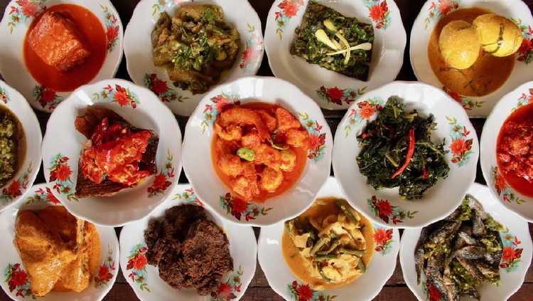 Assortment of Minangkabau dishes served on the table in ‘hidang’ style; means serving the eatery’s menu on the table. The dishes are plated on small ceramic plates and stacked as to save some spaces on the table.