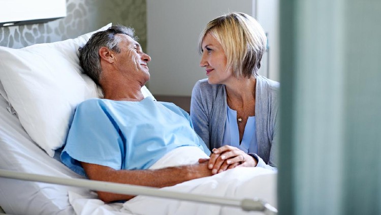 Ilustrasi Merawat Suami Shot of a wife comforting her husband lying in a hospital bed