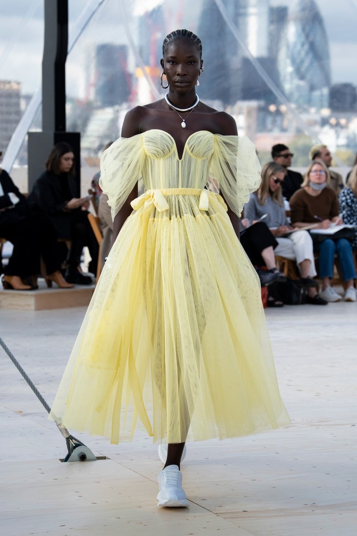 Warna pastel tampil mendominasi bersama rona netral. Burton mengemasnya dalam gaun off-shoulder yang klasik dan feminin. Sentuhan modern hadir pada padanan aksesori berupa sneakers. Foto: Courtesy of Alexander McQueen