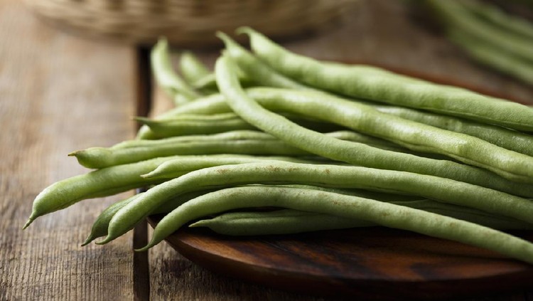 Raw green beans on wooden desk