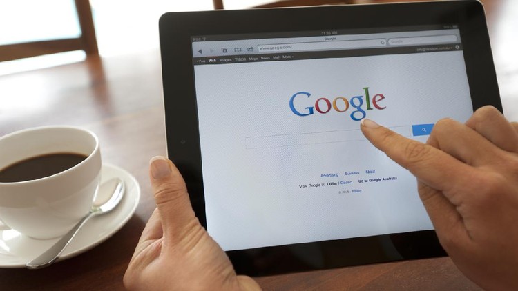 Sydney, Australia - October 28, 2011: Female hand holding an ipad showing Google. She is touching the screen. There is coffee on the dining table in the background.  This image shows the ipad being used in a casual environment.