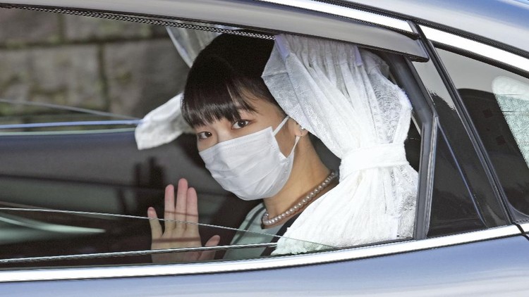 Japan's Princess Mako waves from a car as she leaves her home in Akasaka Estate in Tokyo Tuesday, Oct. 26, 2021. Mako and her commoner boyfriend Kei Komuro tied the knot Tuesday without wedding celebration in a marriage that has split the public opinion over her would-be mother-in-law’s financial controversy. (Chika Oshima/Kyodo News via AP)