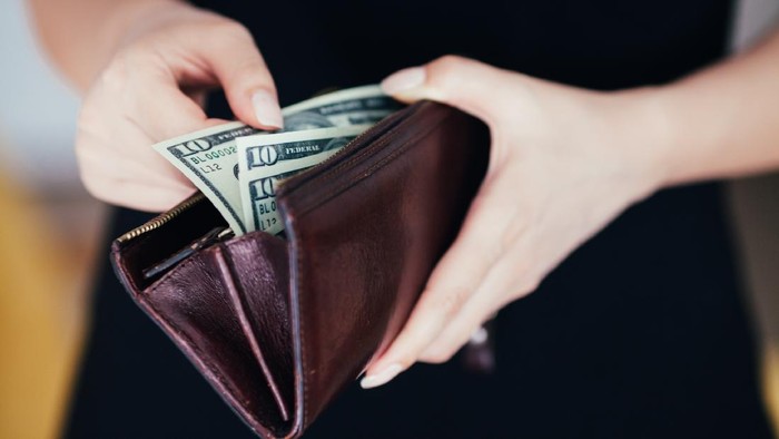 Woman is taking out money from wallet