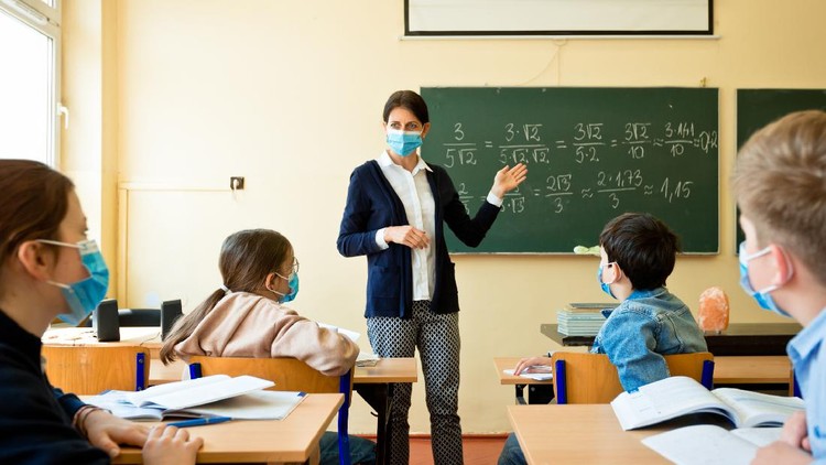 Ilustrasi Sekolah A teacher wearing a N95 Face masks teaches mathematics at an High School
