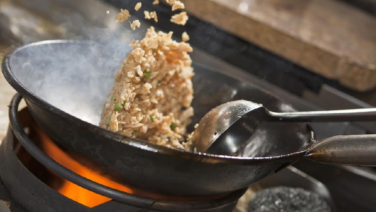 Closeup of fried rice being cooked in wok