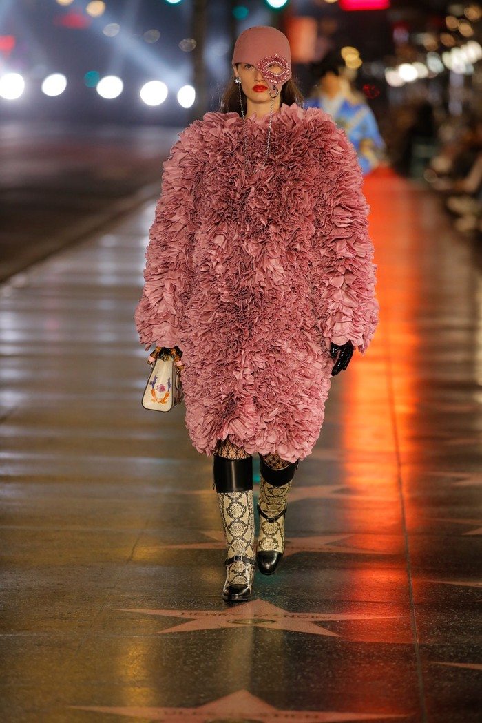Permainan tekstur dan padu padan tabrak warna dan motif menjadi ciri khas rancangan Michele untuk Gucci. Seperti pada mantel yang dikenakan bersama boots motif python ini. Foto: Courtesy of Gucci
