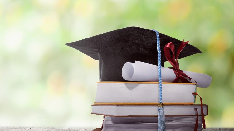 Graduation hat with degree paper on a stack of book against blurred background