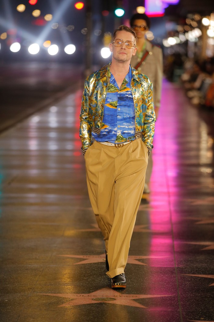 Aktor Macaulay Culkin yang dulu populer berkat film 'Home Alone' mengejutkan para tamu undangan dengan penampilannya sebagai model. Ia mengenakan Hawaiian shirt dan bomber jaket metalik.