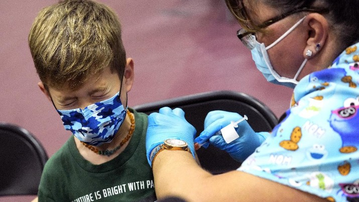 Wren Nagata, 7, of Pasadena grimaces as he receives his COVID-19 vaccine from Jacqueline Valdez during an event kicking off coronavirus vaccinations for children age 5-11 at Eugene A. Obregon Park in Los Angeles on Wednesday, Nov. 3, 2021. (Keith Birmingham/The Orange County Register via AP)