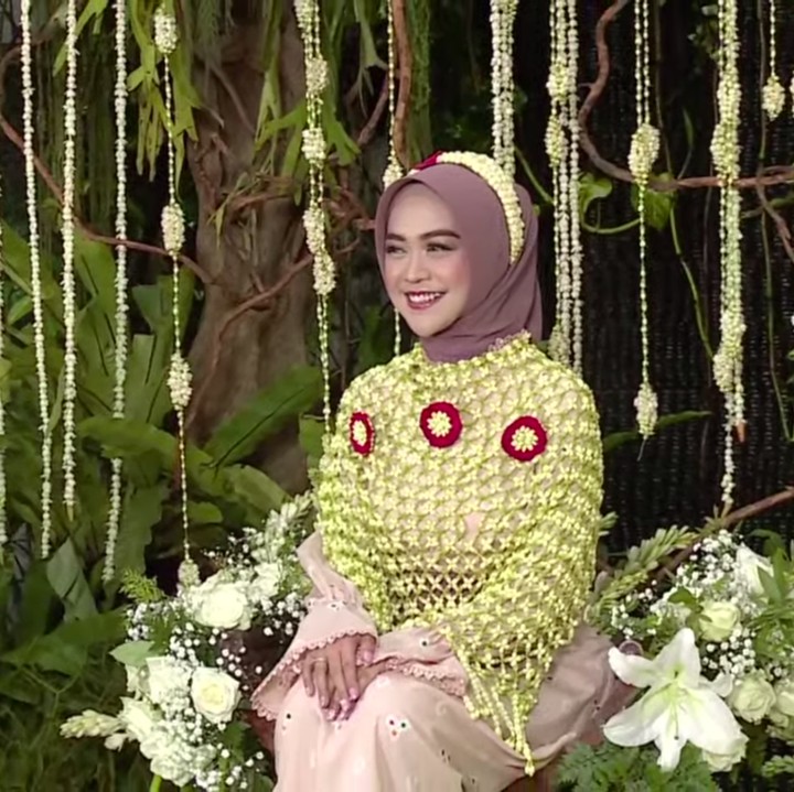 <p>Saat melakukan siraman, Ria Ricis menggunakan rangkaian bunga melati yang cantik, Bunda. Tak hanya di bagian badannya, bunga melati juga terangkai rapi di kepalanya. (Foto: YouTube MOP Channel)</p>
