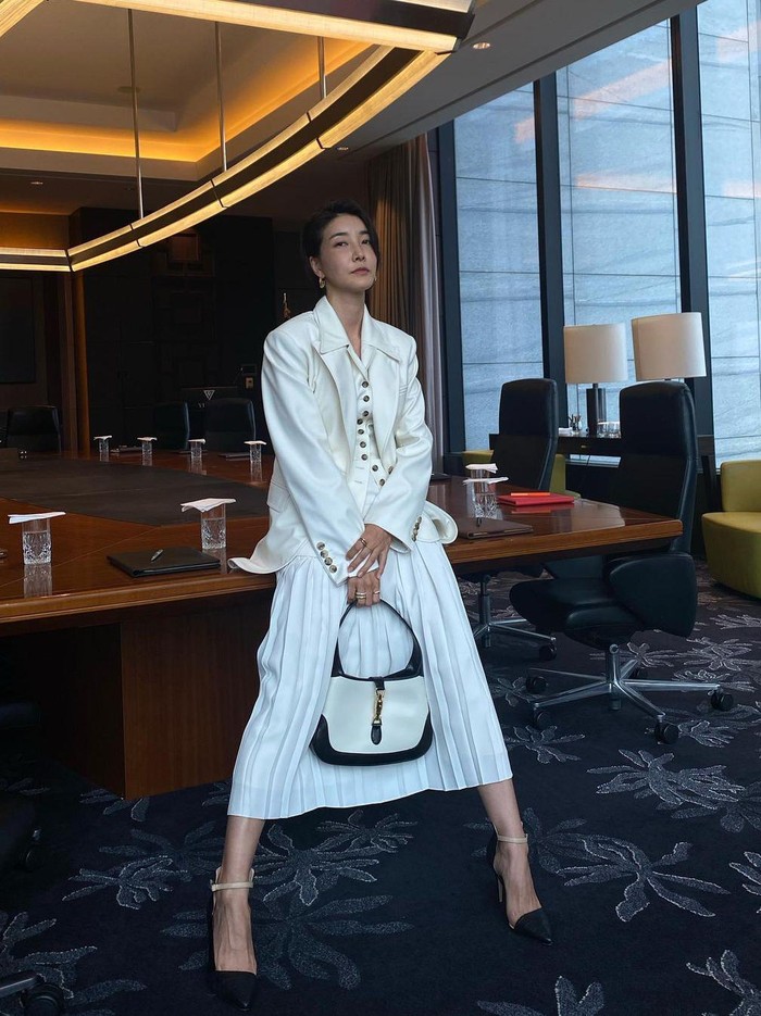 Tak hanya setelan baju kerja super rapi, Sung Hye juga terlihat menawan memakai rok. Makin serasi dengan jas serta tas berwarna senada. Meski jahat, melihat penampilannya bikin