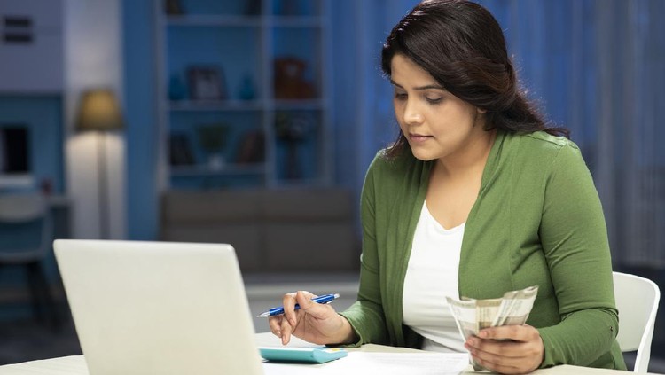 Ilustrasi Keuangan Berantakan mid adult women manage finances calculate bills tax at home
