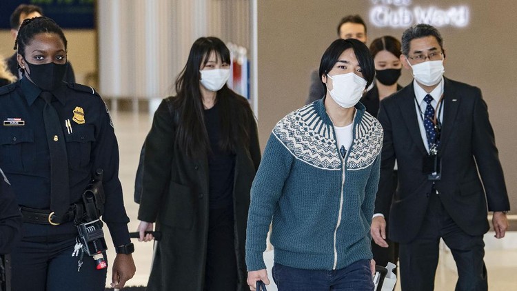 Mako Komuro, former Princess Mako, rear center, and Kei Komuro, front center, arrive at John F. Kennedy International Airport in the Queens borough of New York Sunday, Nov. 14, 2021. The Japanese princess who gave up her royal status to marry her commoner college sweetheart arrived in New York on Sunday, as the couple pursued happiness as newlyweds and left behind a nation that has criticized their romance. (Kyodo News via AP)