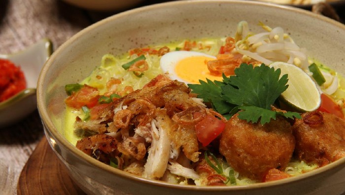Soto Medan, the creamy soup of coconut milk and fried chicken from Medan, North Sumatra. Served together with glass noodles, bean sprouts, egg, potato patty, tomato, celery and fried shallots.