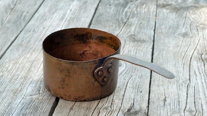 Old vintage copper pots on rustic background