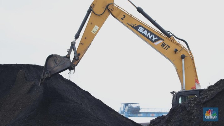 Pekerja membersihkan sisa-sisa batu bara yang berada di luar kapal tongkang pada saat bongkar muat di Pelabuhan Tanjung Priok, Jakarta, Senin (22/11/2021). Pemerintah Indonesia berambisi untuk mengurangi besar-besaran konsumsi batu bara di dalam negeri, bahkan tak mustahil bila meninggalkannya sama sekali. Hal ini tak lain demi mencapai target netral karbon pada 2060 atau lebih cepat, seperti yang dikampanyekan banyak negara di dunia. (CNBC Indonesia/ Tri Susilo)