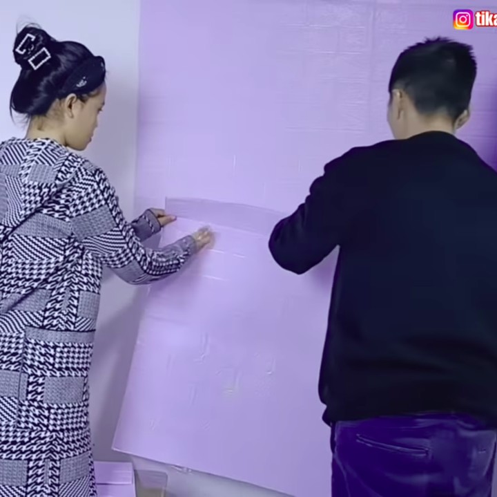 <p>Setelahnya, Weixun dan Tika memasang <em>wallpaper</em> di dinding kamar mereka. Wallpaper yang digunakan memiliki motif batu warna ungu muda. (Foto: YouTube DAILY TIKA WEIXUN DI CHINA)</p>