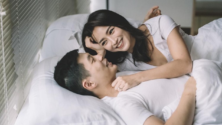 asian chinese couple on bed bonding time in the morning after wake-up