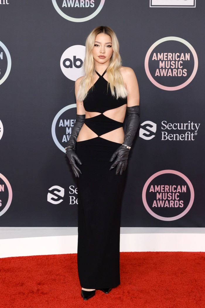 Madelyn Cline yang melejit lewat serial 'Outer Banks' tampil stunning dan seksi dalam gaun detail cutout serta gloves. Foto: Getty Images/Vogue