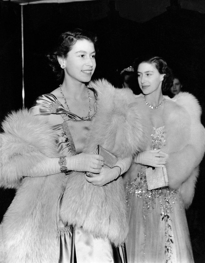 Putri Elizabeth dan Putri Margaret berbalutkan gaun pesta dengan stola bulu untuk menghadiri sebuah pertunjukan di London tahun 1949. Foto: pinterest.com/Town & Country Magazine