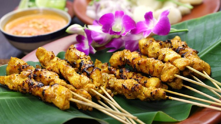 chicken satay, sate ayam and lontong with peanut sauce, indonesian skewer cuisine