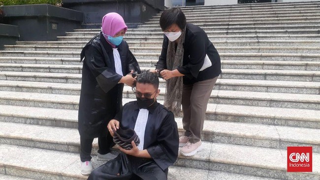 Perwakilan buruh sekaligus pemohon uji formil UU 11 Tahun 2020 tentang Cipta Kerja melakukan aksi cukur botak rambut di depan MK.