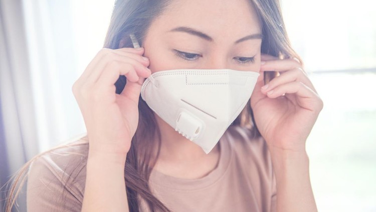 masker katup Female wearing N95 Respiratory Protection Mask against air pollution. Healthcare concept