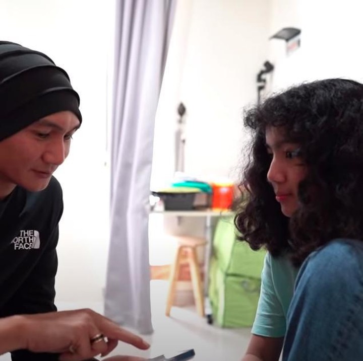 <p>Di kesempatan yang terbilang langka itu, Anji tampaknya ingin menggali potensi dan bakat Leticia dalam musik. Ia tak membawa gitarnya, tapi memakai aplikasi musik yang ada di ponselnya untuk tahu suara Leticia. (Foto: YouTube Sheila Marcia & AwesomeFam)</p>