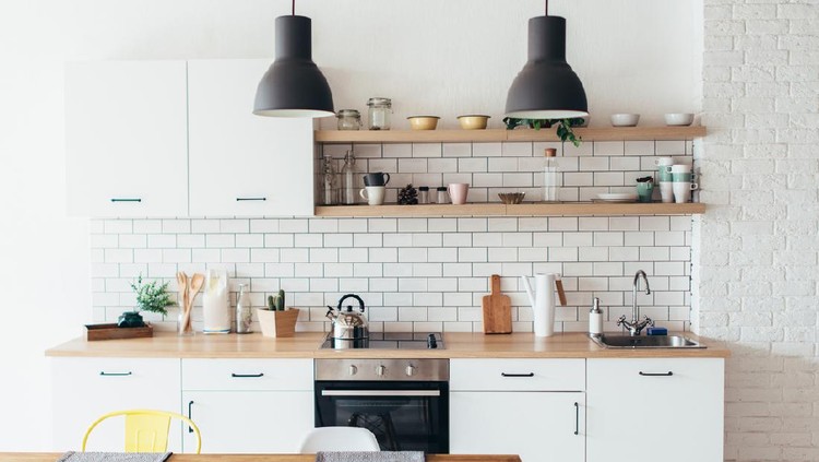 Modern new light interior of kitchen with white furniture and dining table