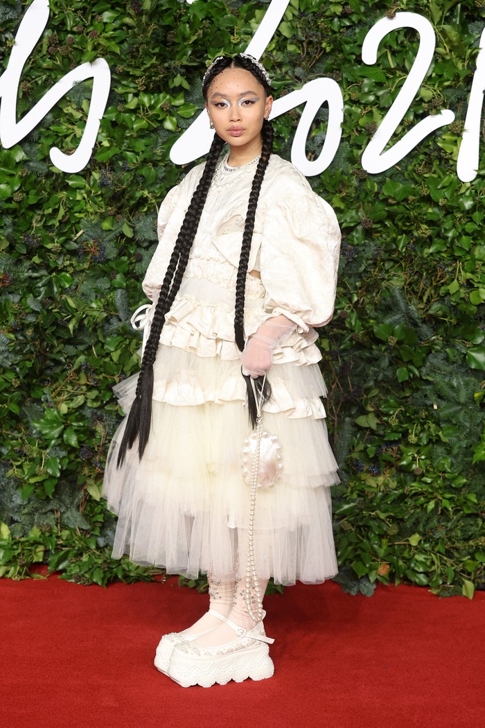 Penampilan Griff di red carpet The Fashion Awards 2021 semalam tidak bisa terlewatkan. Mulai dari tulle dress kreasi Simone Rocha, chunky shoes, hingga gaya rambut kepang panjang memberikan kesan mendalam. Foto: vogue.com