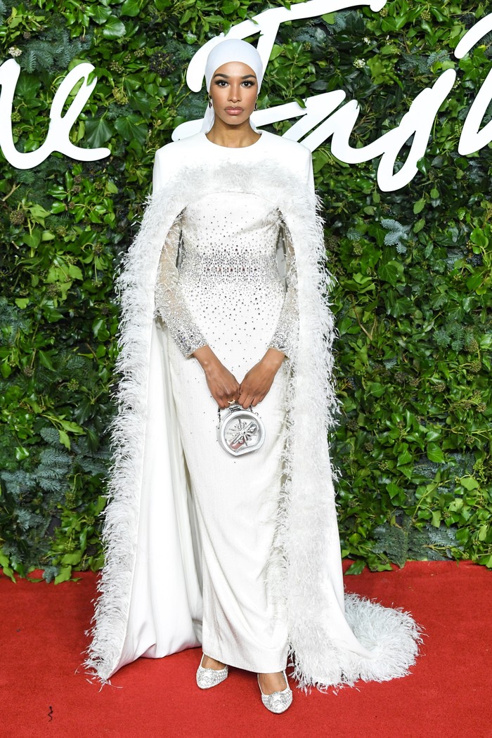 Tampil glamor di red carpet Royal Albert Hall, Ikram Abdi Omar mengenakan pakaian serba putih, mulai dari hijab hingga cape dress berdetail fur. Foto: vogue.com
