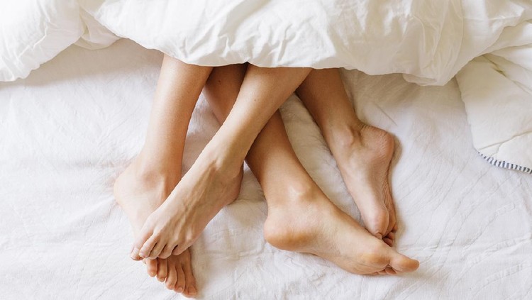 ilustrasi berhubungan seks Close up of female feet in under the sheets.
