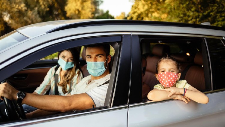 Family taking safety precautions to protect themselves while traveling with a car