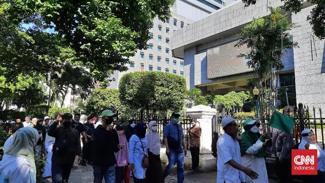 Petugas buru-buru menutup gerbang Gedung DPRD DKI Jakarta saat puluhan massa yang ingin mengikuti reuni 212 bergerak di Jalan Kebon Sirih, Jakarta Pusat.
