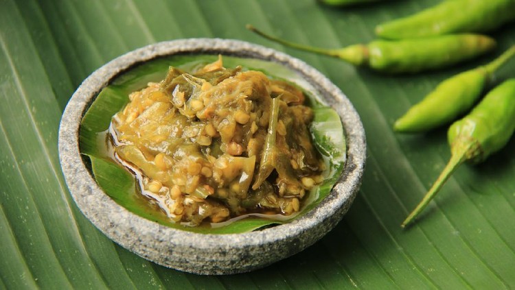 Sambal Lado Mudo or Sambal Lado Ijo is another popular spicy condiment from Padang, West Sumatra. Green chili pepper, shallot, garlic, green tomato are crushed then sautéed. This paste is plated on a saucer of mini stoneware mortar; then placed on a large banana leaf.
