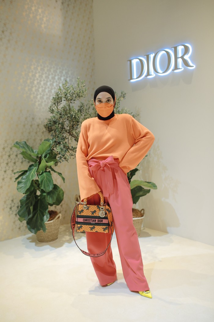 Jangan ragu untuk mengkombinasikan warna vibran seperti oranye dan pink seperti Sari Mulya. Keep it simple dengan pilihan kaus dan celana. Jadikan aksesori seperti tas bermotif playful sebagai statement. Foto: M Rizki Aditya