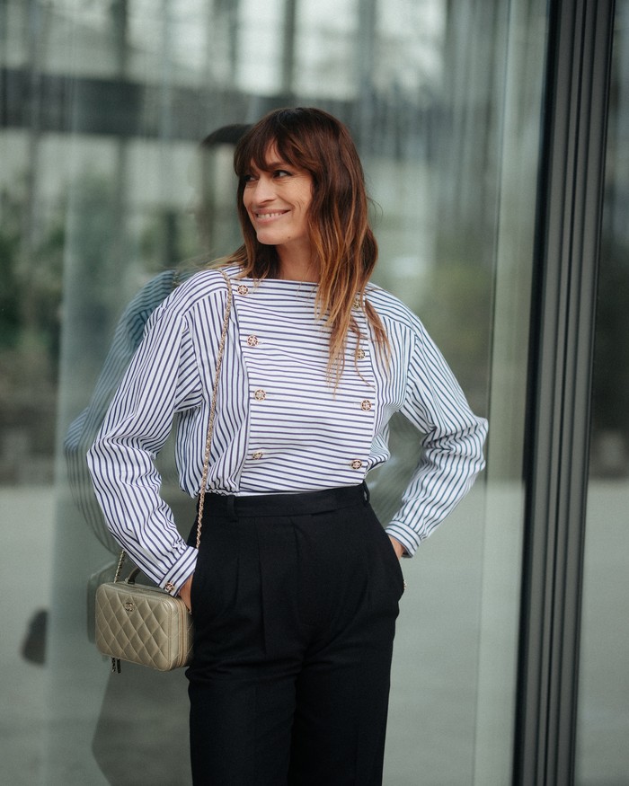 Penulis dan style icon Caroline de Maigret kembali menunjukkan bahwa untuk tampil formal tak harus selalu memakai dress. Ia mengenakan atasan motif garis dan celana  high-waisted. Effortlessly chic! Foto: Courtesy of Chanel