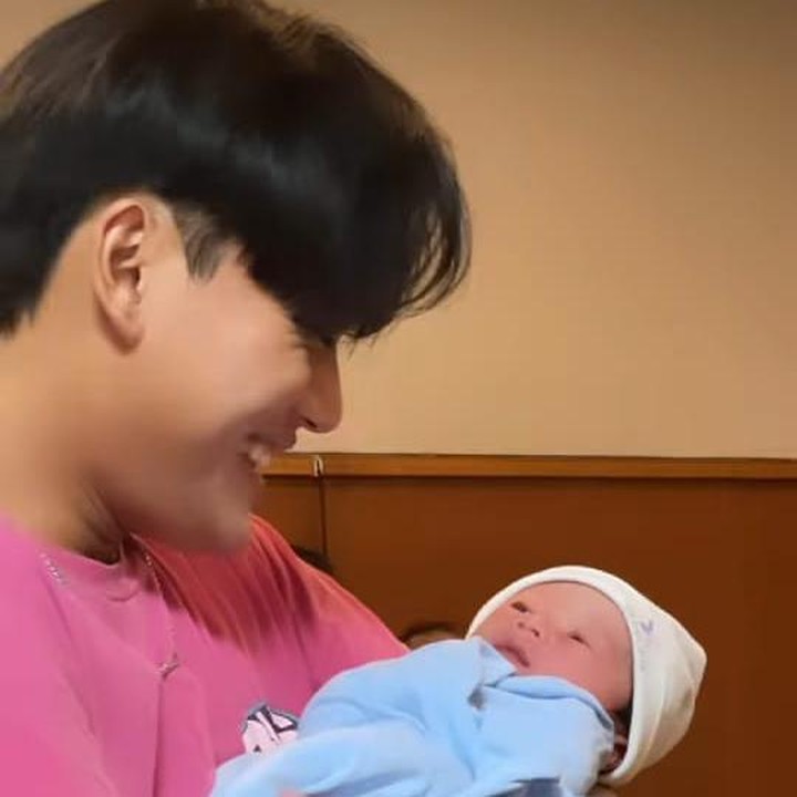 <p>Tak lama si sulung Rizky Febian akhirnya datang untuk melihat baby Adzam. Rizky tersenyum sambil menggendong adik kecilnya itu. (Foto: Instagram @nathalieholscher)</p>
